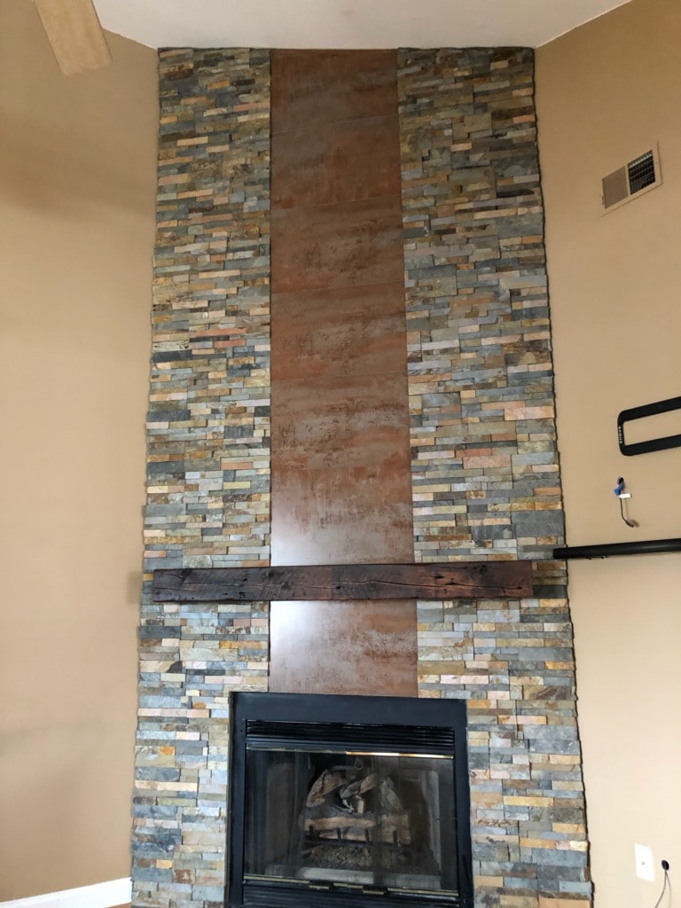 Norstone Ochre Stacked Stone Panels on a floor to ceiling fireplace with a vertical metal insert